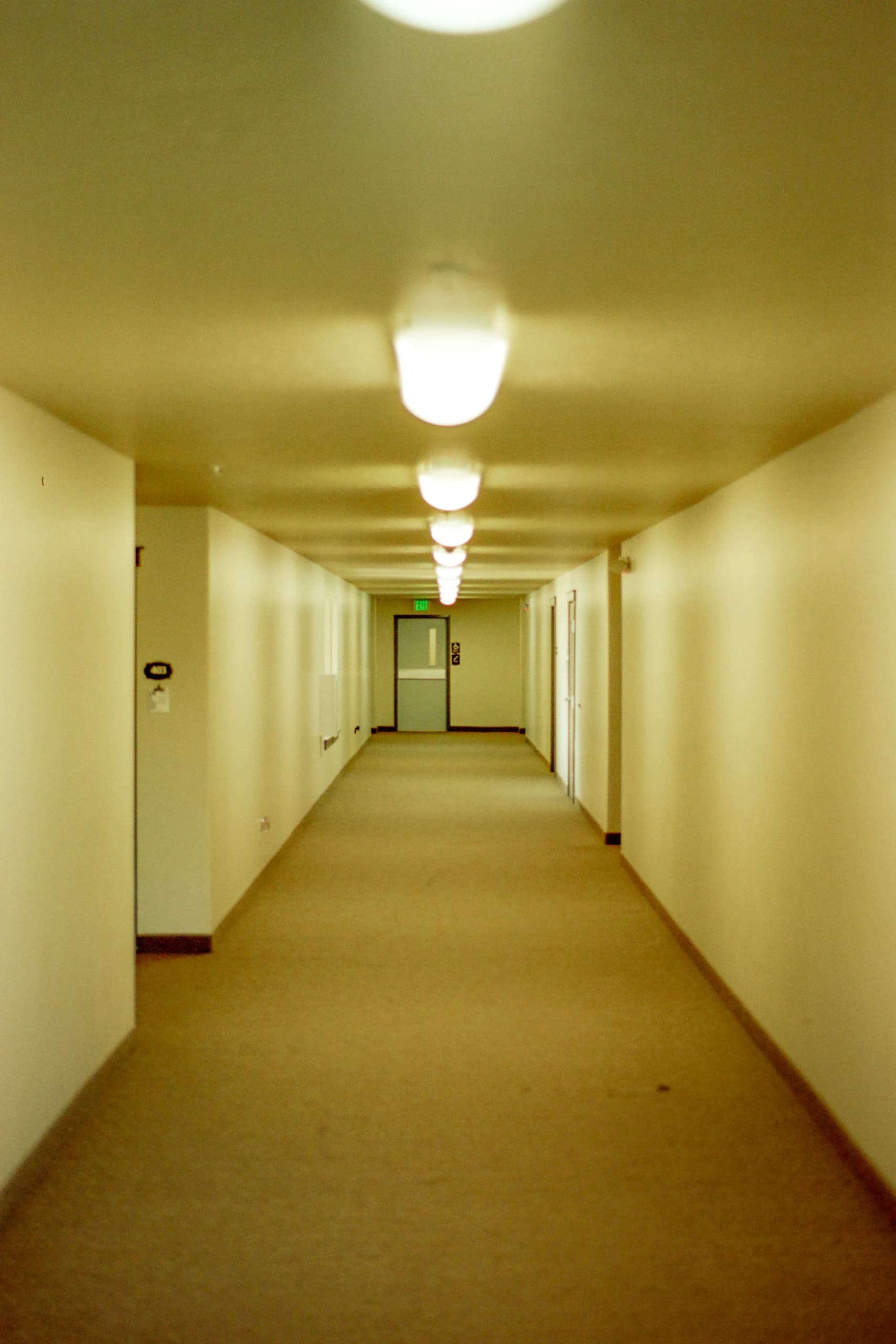 A liminal feeling hallway devoid of much color other than yellow